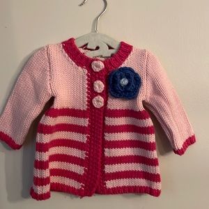 Huggalugs. Size 6-12 mo. Pink with blue rosette. Hand knot infant sweater.